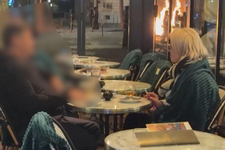 Di Tengah Kerusuhan Paris, Sepasang Kekasih Tetap Asyik Ngopi Meski Sampah Terbakar di Belakang